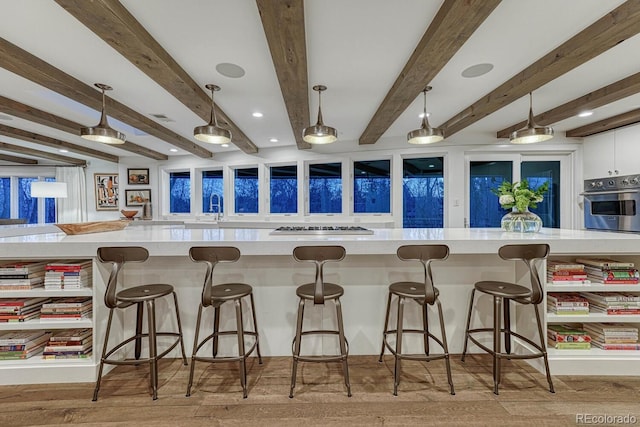 kitchen featuring decorative light fixtures, light countertops, visible vents, light wood-style flooring, and oven