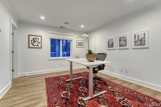 office featuring light wood-style floors, baseboards, visible vents, and crown molding