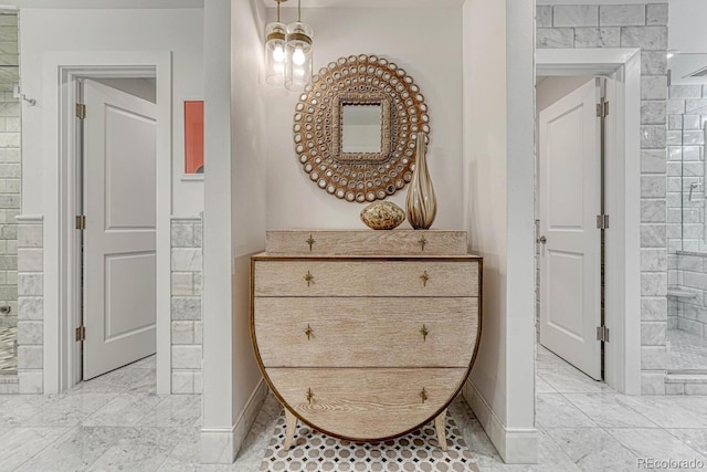 corridor featuring marble finish floor and baseboards