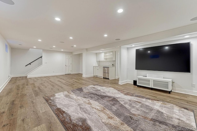 unfurnished living room with baseboards, light wood finished floors, and recessed lighting