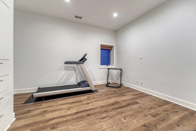 workout room with visible vents, baseboards, and wood finished floors