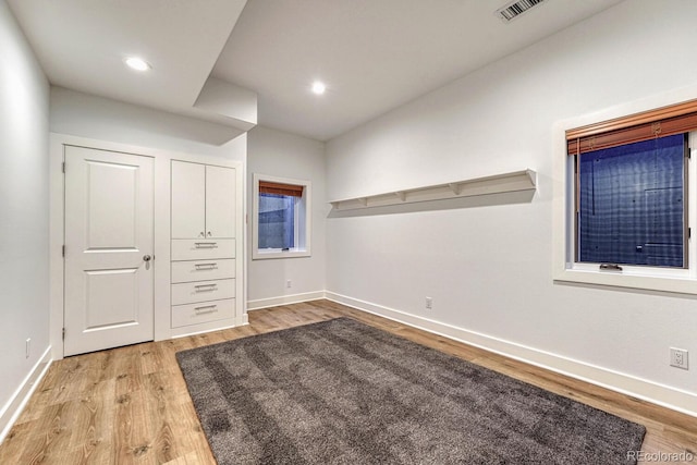 unfurnished room featuring recessed lighting, light wood-type flooring, visible vents, and baseboards