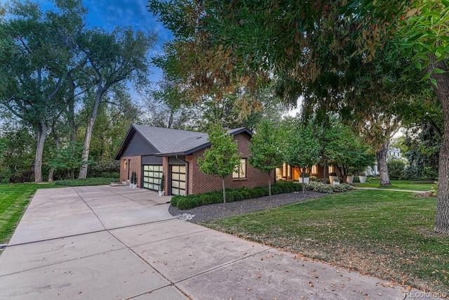 view of side of home with a garage, concrete driveway, brick siding, and a lawn