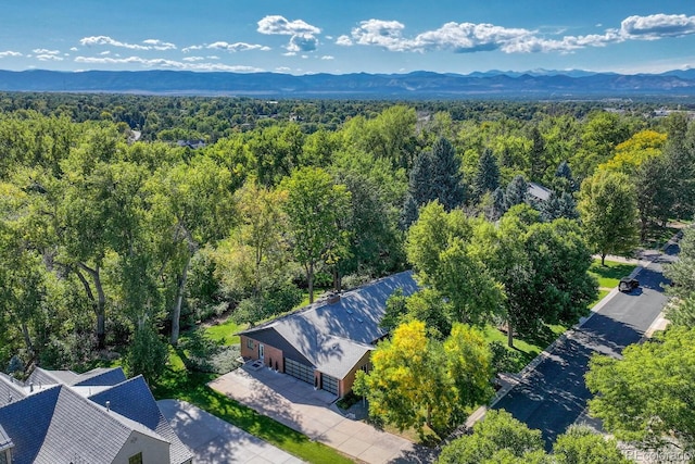 birds eye view of property with a wooded view and a mountain view