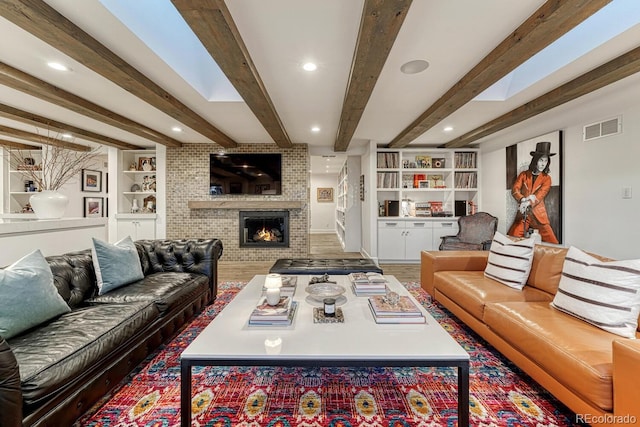 living area with recessed lighting, visible vents, built in features, a brick fireplace, and beam ceiling