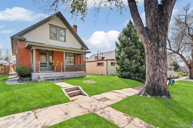2826 Quitman St, Denver, CO 80212 - bungalow-style house featuring covered porch, a chimney, brick siding, and a front lawn