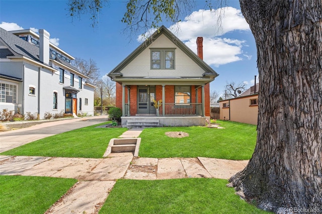 2826 Quitman St, Denver, CO 80212 - bungalow with a porch, brick siding, a front yard, and a chimney