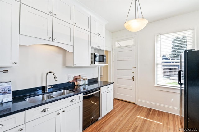 2826 Quitman St, Denver, CO 80212 - kitchen featuring black appliances, light wood-type flooring, plenty of natural light, and dark countertops