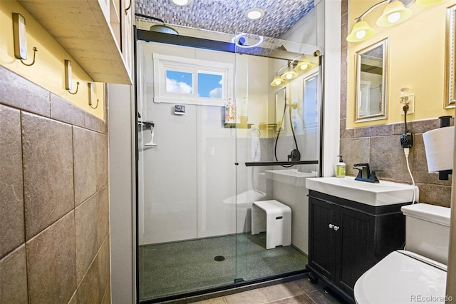 3811 N Clay St, Denver, CO 80211 - full bath featuring tile walls, a wainscoted wall, a shower stall, toilet, and vanity