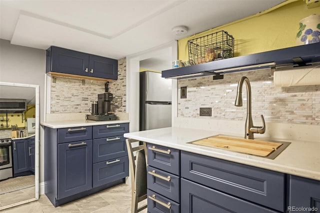 3811 N Clay St, Denver, CO 80211 - kitchen with light countertops, a sink, tasteful backsplash, appliances with stainless steel finishes, and blue cabinets