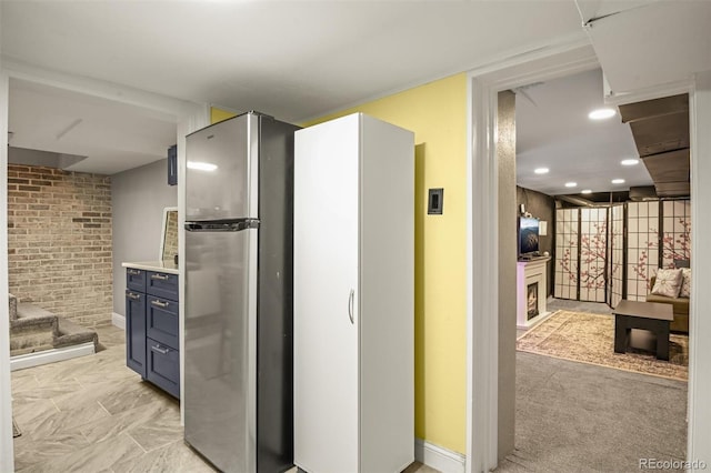 3811 N Clay St, Denver, CO 80211 - kitchen with blue cabinetry, light countertops, brick wall, and freestanding refrigerator
