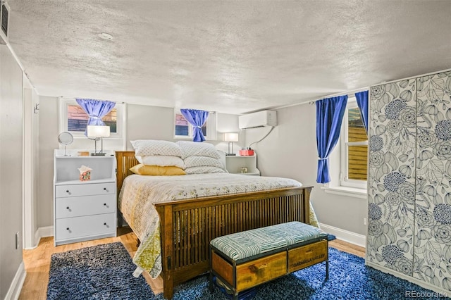 3811 N Clay St, Denver, CO 80211 - bedroom featuring baseboards, a textured ceiling, a wall mounted air conditioner, and wood finished floors