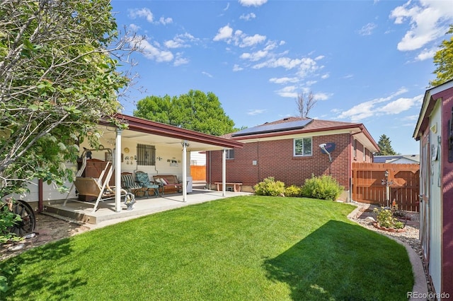 11349 Downing Dr, Northglenn, CO 80233 - rear view of house featuring roof mounted solar panels, brick siding, and a patio