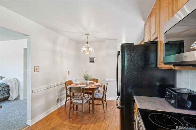11349 Downing Dr, Northglenn, CO 80233 - kitchen featuring stainless steel microwave, light wood-style floors, a chandelier, and electric range