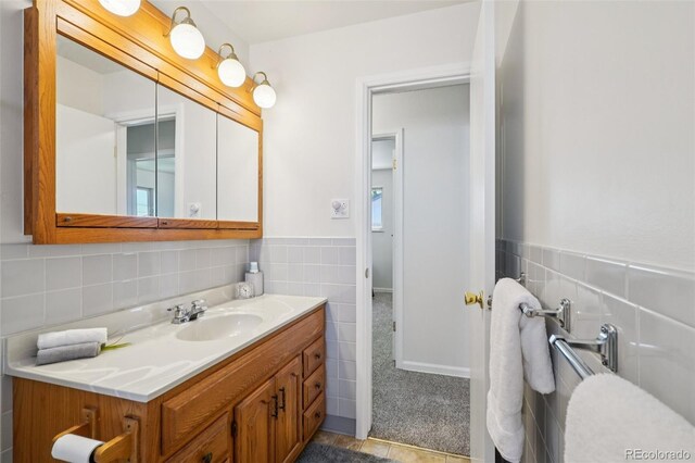 11349 Downing Dr, Northglenn, CO 80233 - bathroom featuring tile walls, vanity, and a wainscoted wall