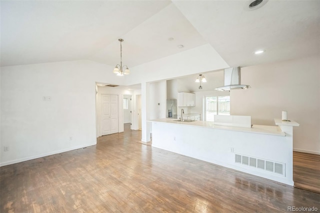 7010 W 44th Ave, Wheat Ridge, CO 80033 - unfurnished living room featuring wood finished floors, a chandelier, and vaulted ceiling