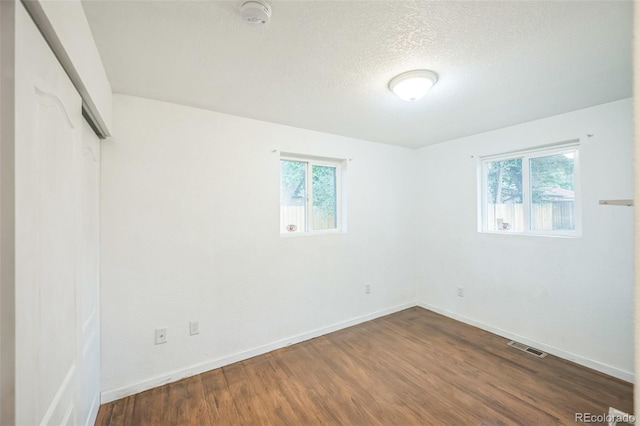 7010 W 44th Ave, Wheat Ridge, CO 80033 - unfurnished bedroom with dark wood-style flooring, a closet, and a textured ceiling