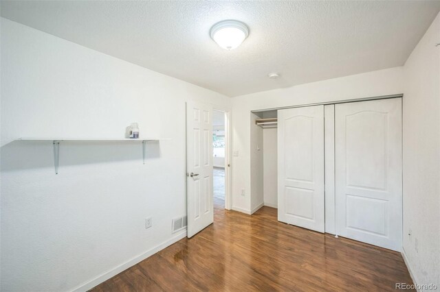 7010 W 44th Ave, Wheat Ridge, CO 80033 - unfurnished bedroom with wood finished floors, a closet, and a textured ceiling