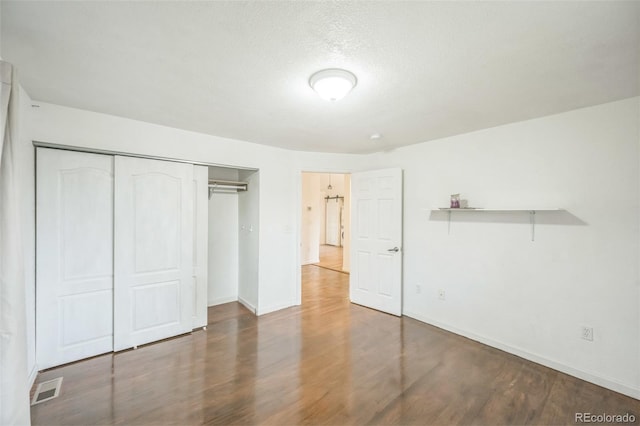 7010 W 44th Ave, Wheat Ridge, CO 80033 - unfurnished bedroom with wood finished floors, a closet, and a textured ceiling