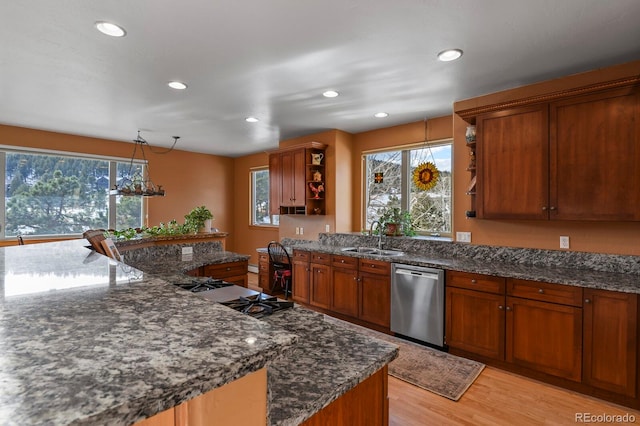 kitchen with dark stone counters, dishwasher, light hardwood / wood-style floors, and sink