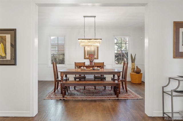 dining area featuring dark hardwood / wood-style flooring, crown molding, and a chandelier