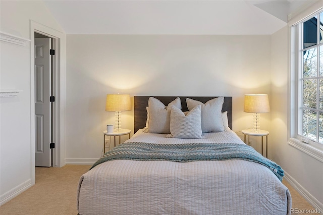 bedroom with light colored carpet and vaulted ceiling