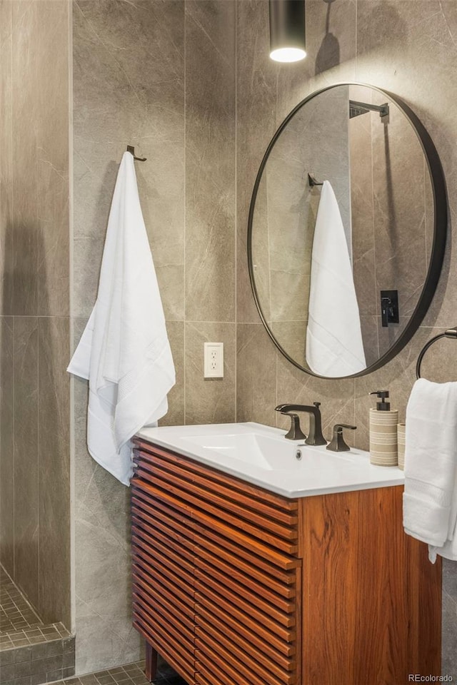 bathroom with decorative backsplash, vanity, and tile walls