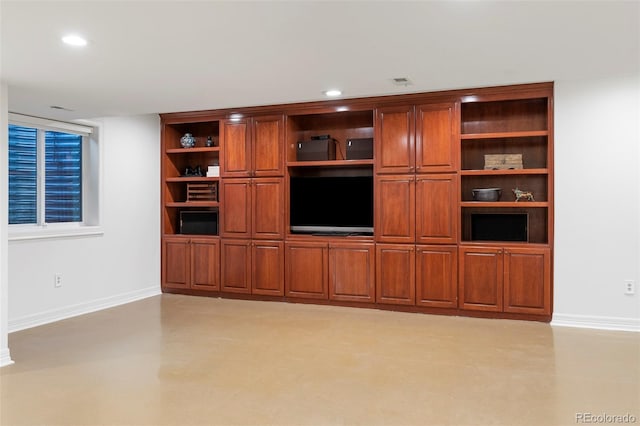 unfurnished living room featuring built in shelves