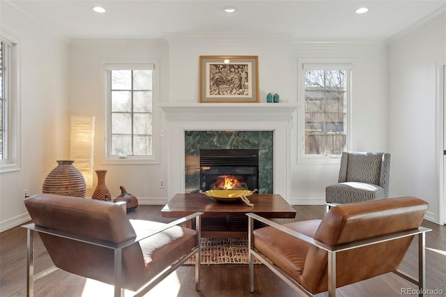 living area with plenty of natural light, a fireplace, ornamental molding, and dark wood-type flooring