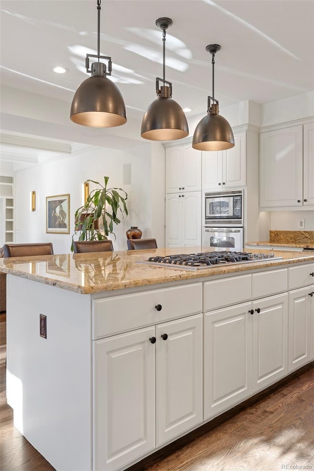 kitchen with dark hardwood / wood-style floors, white cabinetry, stainless steel appliances, and hanging light fixtures