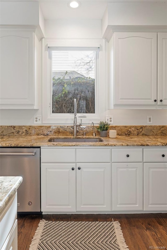 kitchen with white cabinets, dishwasher, light stone countertops, and sink