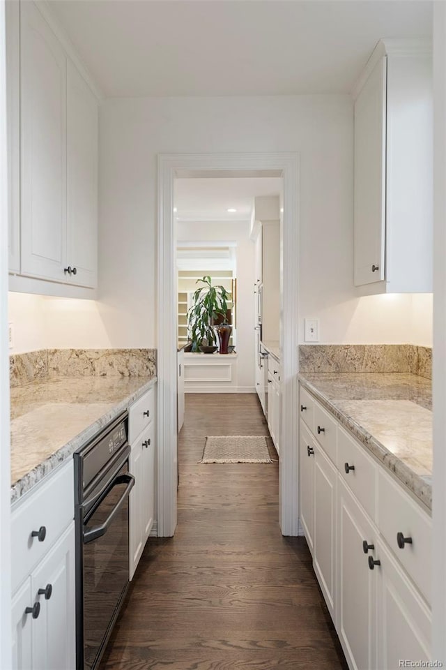 kitchen featuring white cabinetry, dark wood-type flooring, and light stone counters