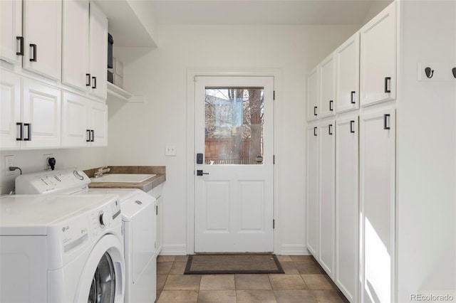 laundry room featuring washing machine and dryer, sink, light tile patterned floors, and cabinets