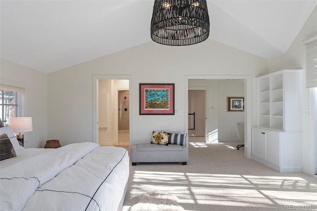 bedroom featuring connected bathroom, light colored carpet, and lofted ceiling