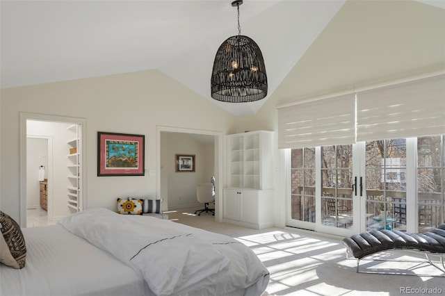 carpeted bedroom featuring lofted ceiling, a spacious closet, and a chandelier