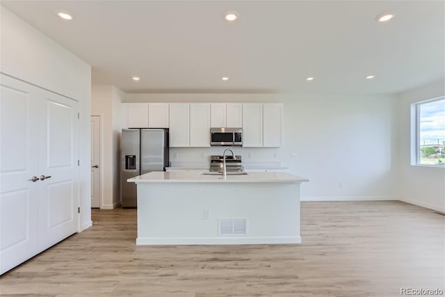 kitchen featuring sink, stainless steel appliances, light hardwood / wood-style floors, a kitchen island with sink, and white cabinets