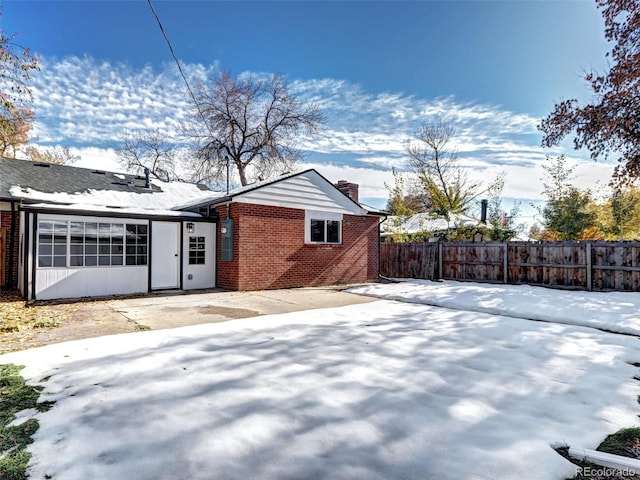 exterior space with a patio, brick siding, a chimney, and fence