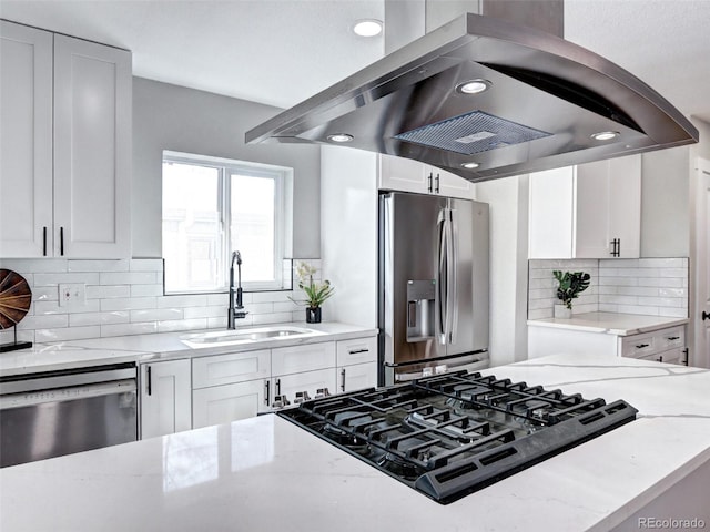 kitchen with white cabinets, island exhaust hood, stainless steel appliances, and a sink