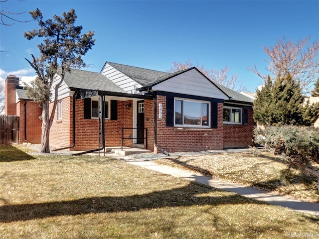 bungalow featuring a front yard, brick siding, and fence