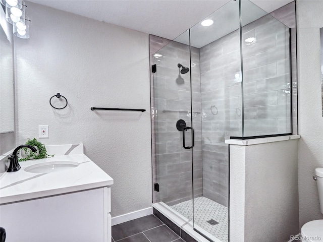 bathroom with vanity, tile patterned flooring, a shower stall, and toilet