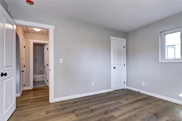 unfurnished room with wood finished floors and baseboards