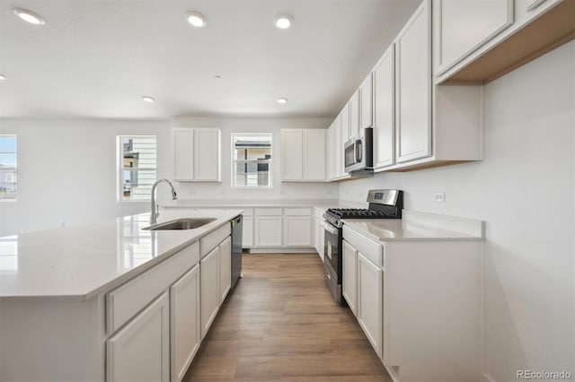 9061 Telluride Ct, Commerce City, CO 80022 - kitchen with stainless steel appliances, a sink, light countertops, light wood finished floors, and recessed lighting
