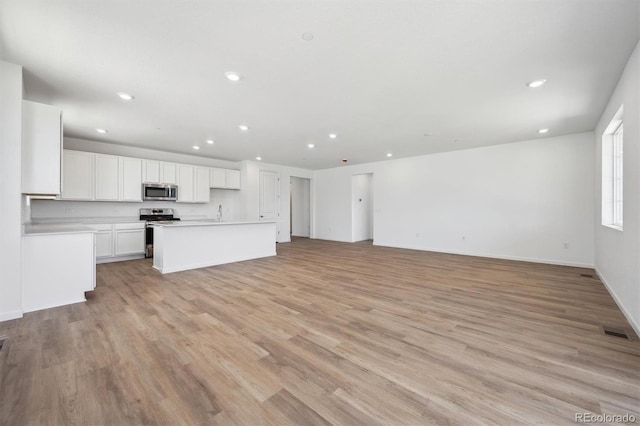 9061 Telluride Ct, Commerce City, CO 80022 - unfurnished living room with recessed lighting, light wood-style floors, and baseboards