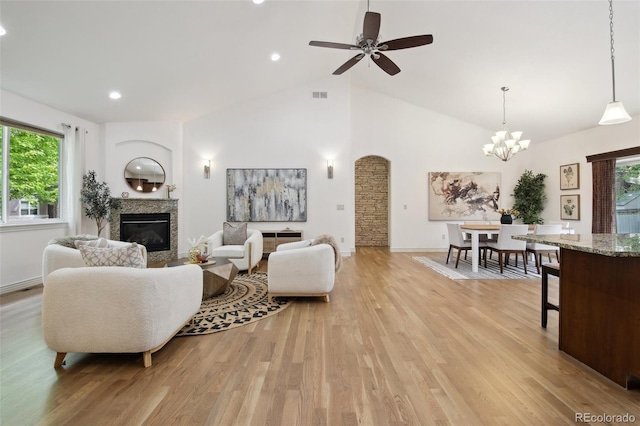 1235 S Balsam St, Lakewood, CO 80232 - living area with a glass covered fireplace, plenty of natural light, light wood-style floors, a chandelier, and high vaulted ceiling