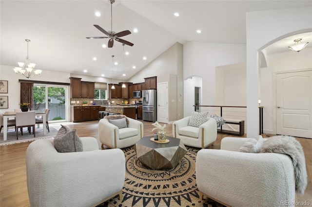 1235 S Balsam St, Lakewood, CO 80232 - living room with arched walkways, ceiling fan, light wood-style flooring, a chandelier, and high vaulted ceiling
