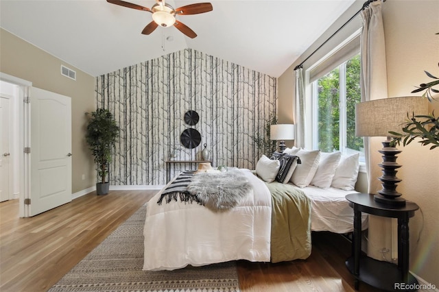 1235 S Balsam St, Lakewood, CO 80232 - bedroom featuring vaulted ceiling, an accent wall, wood finished floors, wallpapered walls, and a ceiling fan