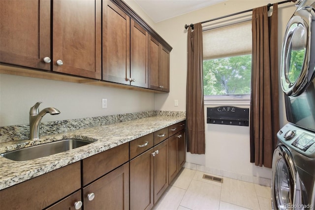 1235 S Balsam St, Lakewood, CO 80232 - washroom featuring stacked washer / dryer, cabinet space, and light tile patterned floors