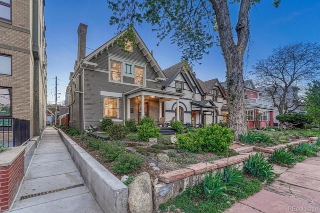 view of front of property featuring a chimney and brick siding
