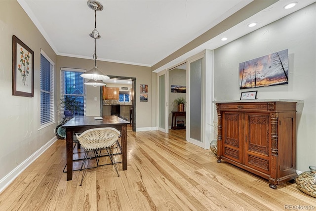 dining room with ornamental molding, light wood-style flooring, baseboards, and recessed lighting