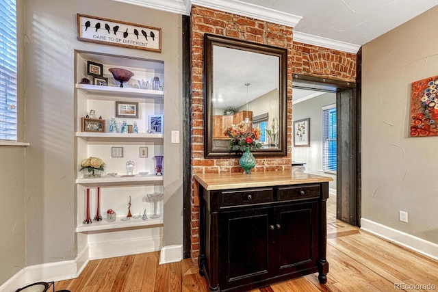interior space featuring crown molding, baseboards, and light wood-type flooring